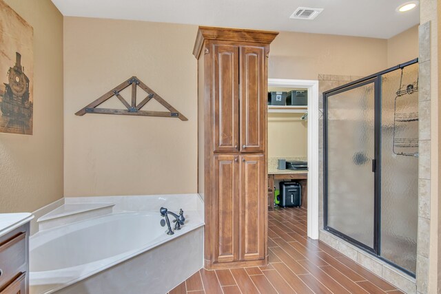 bathroom featuring vanity and independent shower and bath