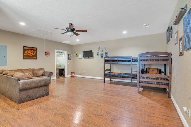 bedroom with ceiling fan, wood-type flooring, and electric panel