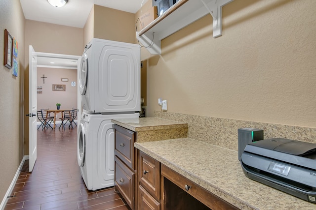 laundry area with dark hardwood / wood-style flooring and stacked washer / dryer