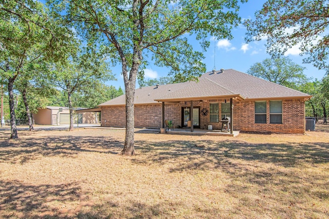 rear view of property featuring a storage shed