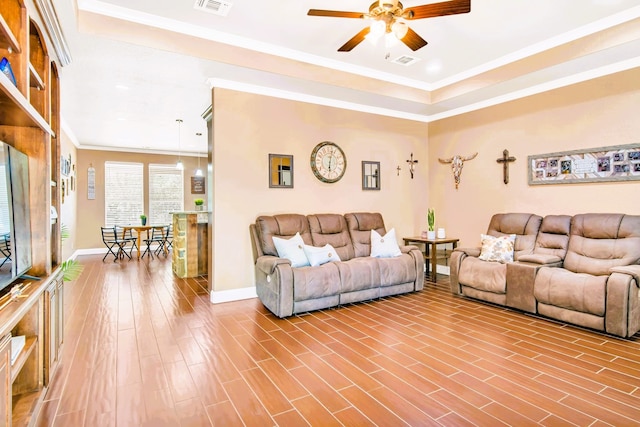 living room featuring wood-type flooring, ceiling fan, and ornamental molding