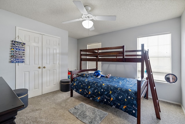 bedroom featuring carpet, a textured ceiling, a closet, and ceiling fan