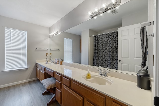 bathroom with a wealth of natural light, vanity, wood-type flooring, and a shower with shower curtain