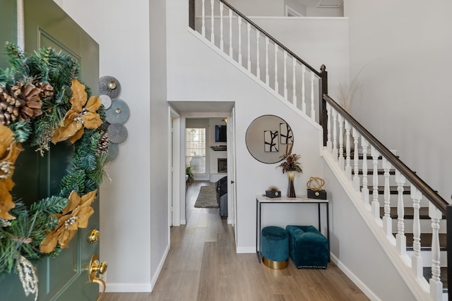 stairway featuring a towering ceiling and wood-type flooring