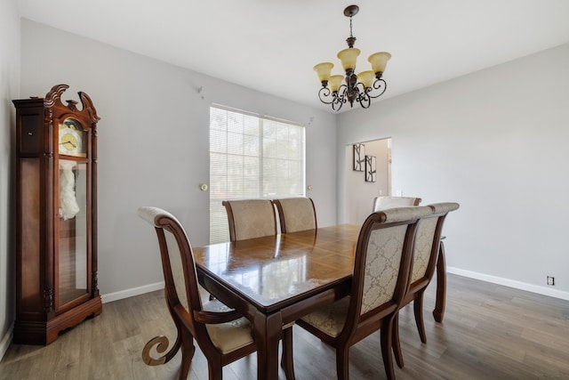 dining area with a notable chandelier and hardwood / wood-style flooring