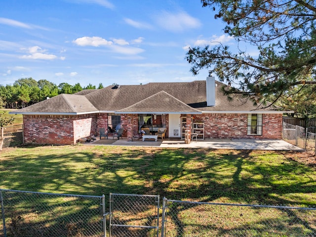 rear view of house with a yard and a patio