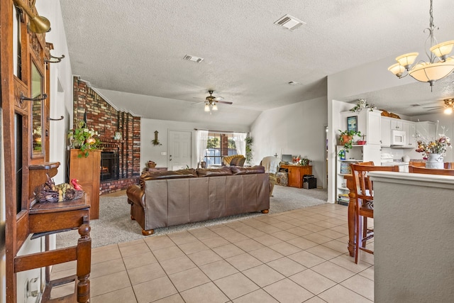 carpeted living room featuring a textured ceiling, ceiling fan with notable chandelier, lofted ceiling, and a fireplace