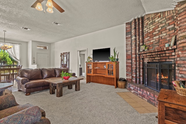 carpeted living room featuring ceiling fan with notable chandelier, a textured ceiling, a brick fireplace, and vaulted ceiling