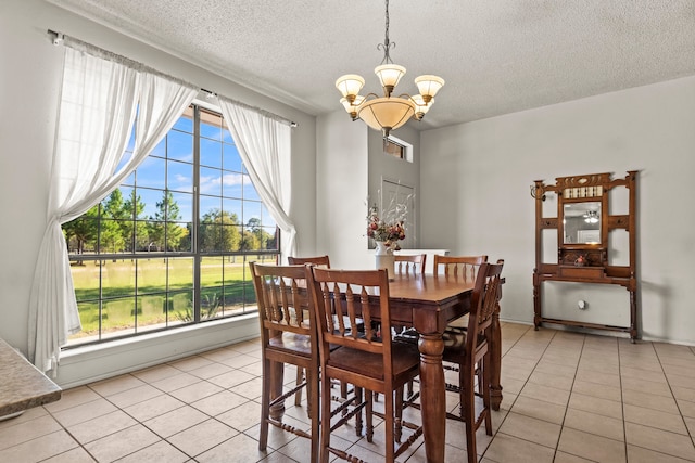 tiled dining room with a healthy amount of sunlight, a textured ceiling, and a notable chandelier