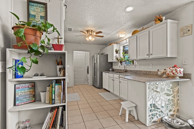 kitchen with white cabinetry, ceiling fan, sink, a textured ceiling, and light tile patterned floors