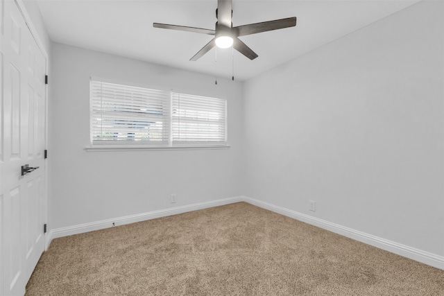 carpeted spare room featuring ceiling fan