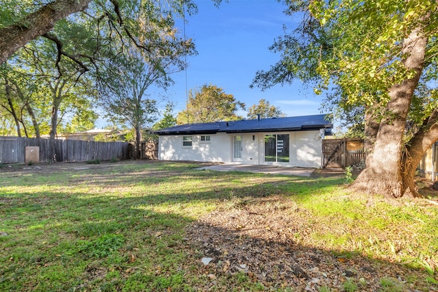 rear view of house with a yard and a patio