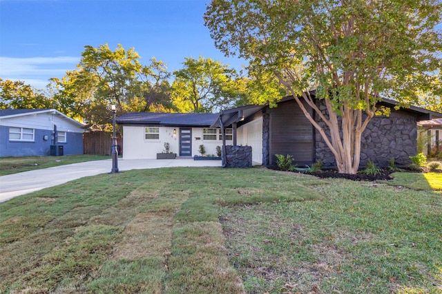 single story home with central AC, a front yard, and a garage