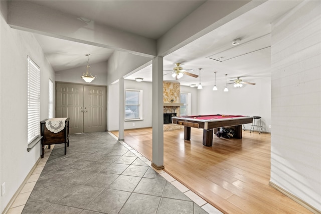 game room featuring a stone fireplace, billiards, vaulted ceiling, ceiling fan, and wood-type flooring