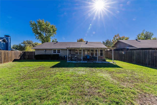 back of property featuring a lawn and a patio area