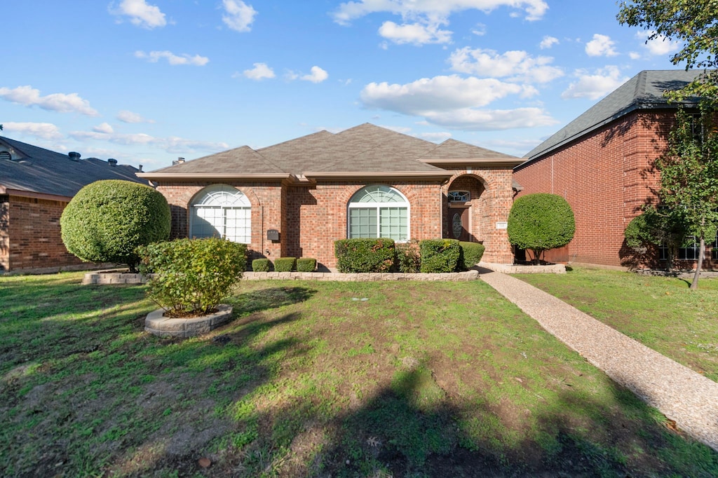 ranch-style home with a front lawn