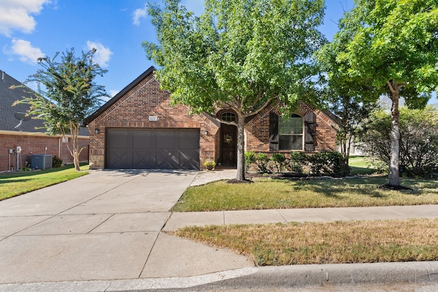 view of front of house featuring cooling unit, a garage, and a front lawn