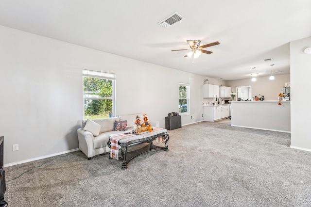 living room with carpet flooring, plenty of natural light, ceiling fan, and sink