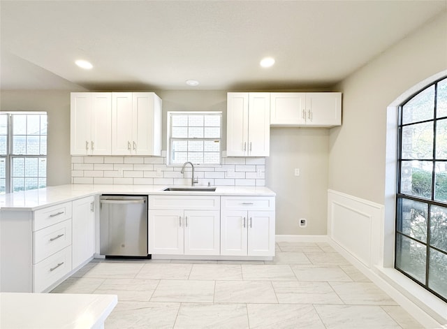 kitchen featuring white cabinetry, dishwasher, and sink