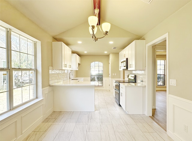 kitchen featuring kitchen peninsula, electric range, white cabinets, and sink