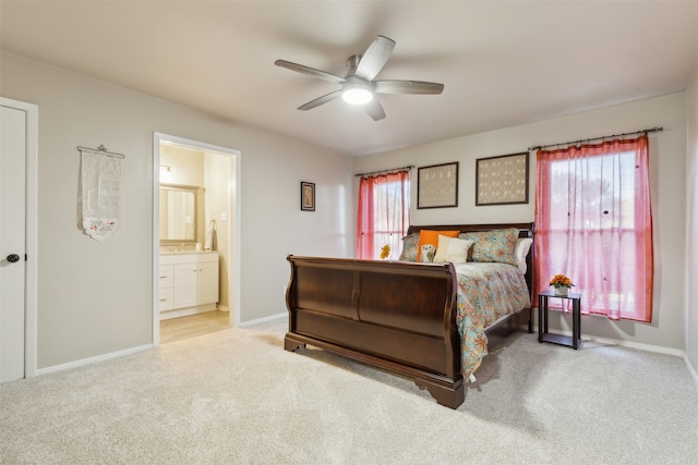 carpeted bedroom with ceiling fan, ensuite bath, and multiple windows