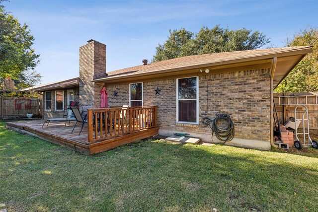 rear view of house with a lawn and a wooden deck