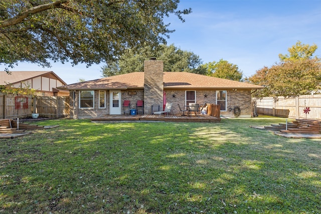 rear view of house with a lawn and a deck