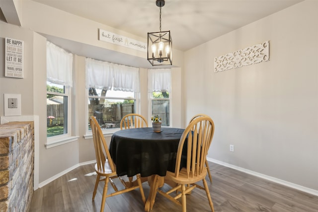 dining room featuring dark hardwood / wood-style flooring and an inviting chandelier