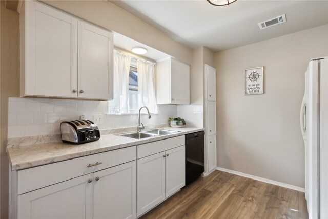 kitchen with sink, hardwood / wood-style flooring, white cabinets, black dishwasher, and white fridge