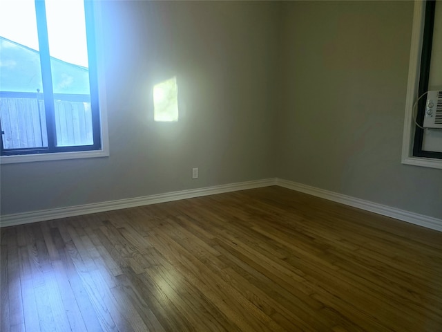 unfurnished room with dark hardwood / wood-style flooring