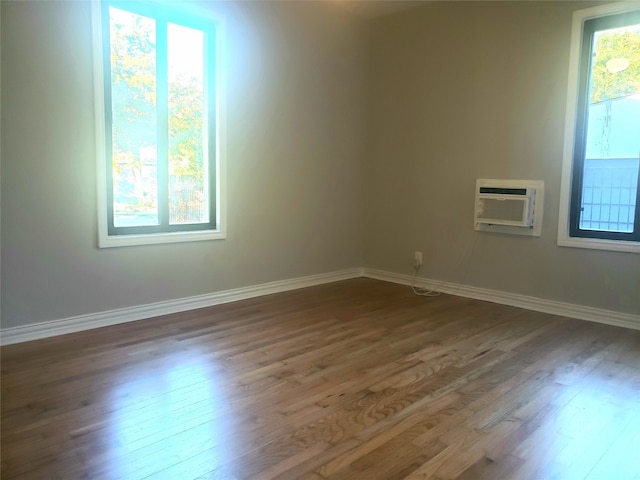 spare room with a wall mounted air conditioner and dark wood-type flooring