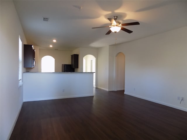 unfurnished living room featuring ceiling fan and dark hardwood / wood-style floors