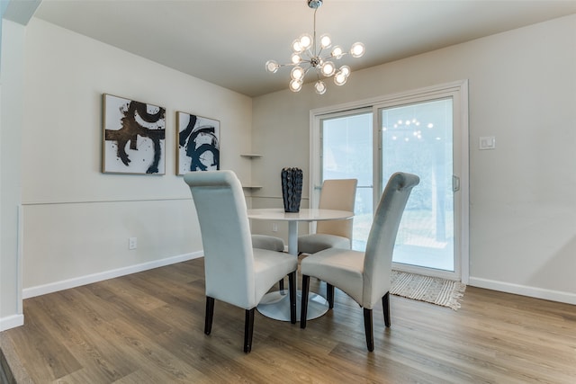 dining room featuring wood-type flooring and an inviting chandelier