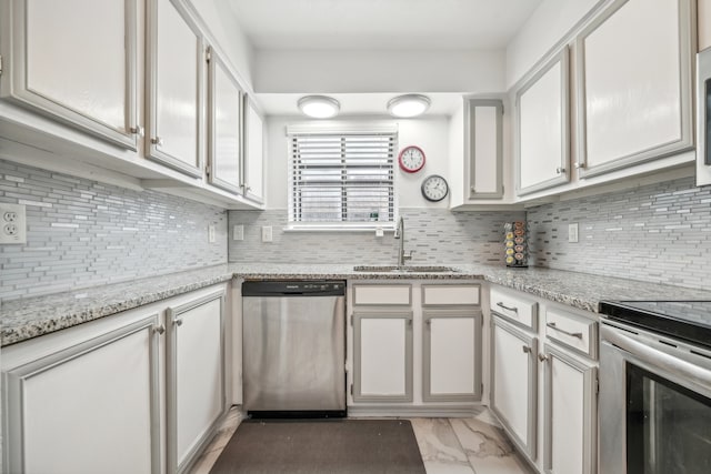 kitchen with white cabinetry, sink, light stone countertops, backsplash, and appliances with stainless steel finishes