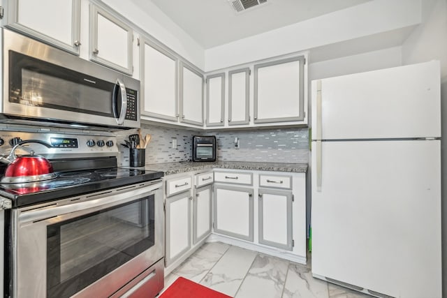 kitchen with white cabinets, decorative backsplash, and appliances with stainless steel finishes