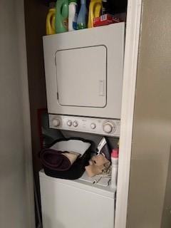 clothes washing area featuring stacked washer and clothes dryer