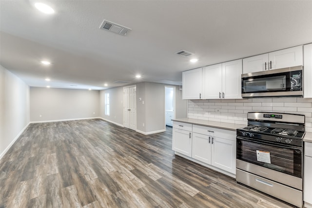 kitchen with decorative backsplash, dark hardwood / wood-style flooring, white cabinetry, and appliances with stainless steel finishes