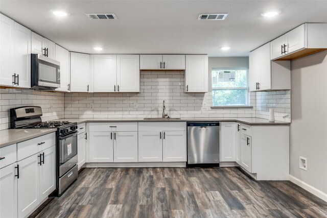 kitchen with white cabinets, appliances with stainless steel finishes, and sink