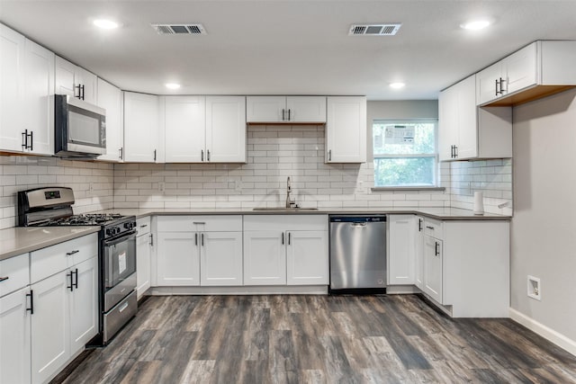6614 Parkdale Dr, Dallas, TX 75227 - kitchen with appliances with stainless steel finishes, a sink, dark wood-style floors, baseboards, and white cabinets