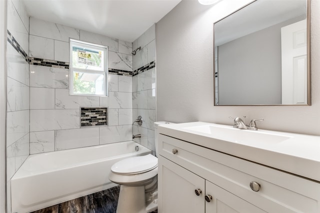 full bathroom with vanity, hardwood / wood-style floors, tiled shower / bath combo, and toilet