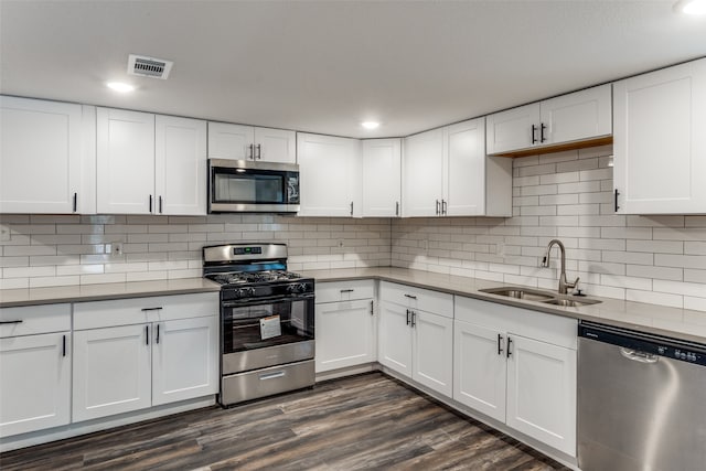 kitchen featuring stainless steel appliances, white cabinetry, and dark hardwood / wood-style floors