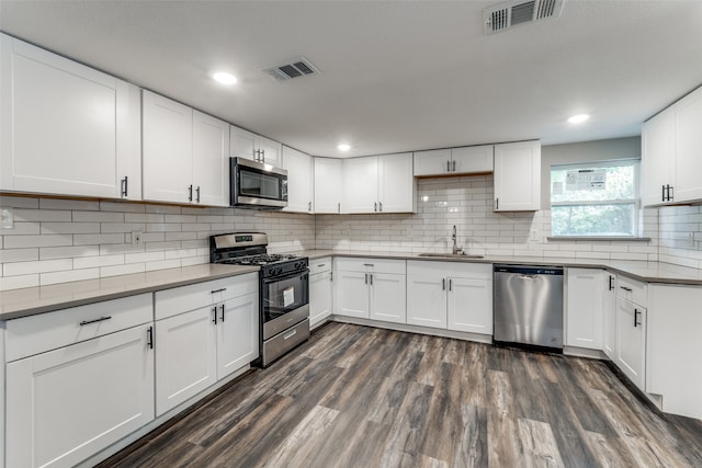 kitchen with dark hardwood / wood-style flooring, sink, white cabinets, and stainless steel appliances