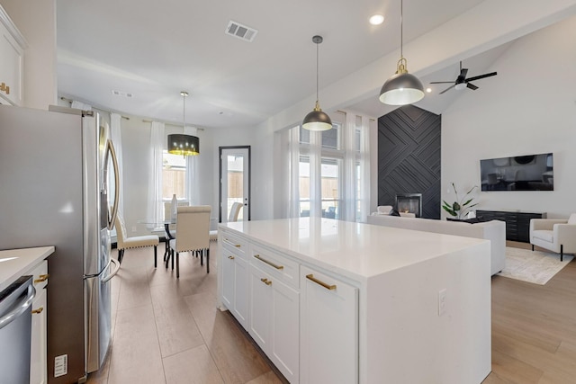 kitchen with stainless steel appliances, hanging light fixtures, a center island, and white cabinets