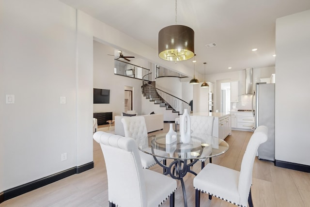 dining area with ceiling fan and light wood-type flooring