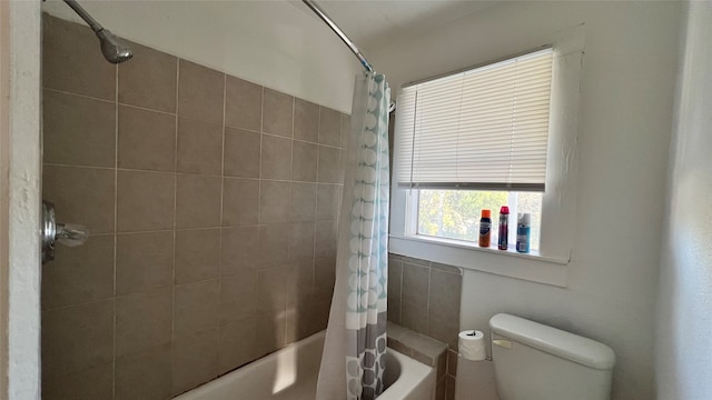 bathroom featuring toilet and shower / bathtub combination with curtain