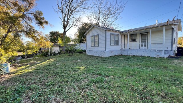 view of side of home with a lawn and a porch