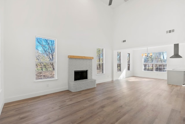 unfurnished living room featuring a fireplace, plenty of natural light, and light wood-type flooring