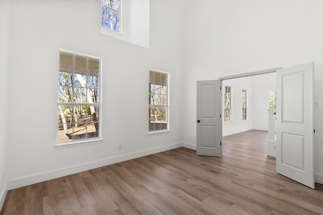 spare room featuring a high ceiling and light hardwood / wood-style floors