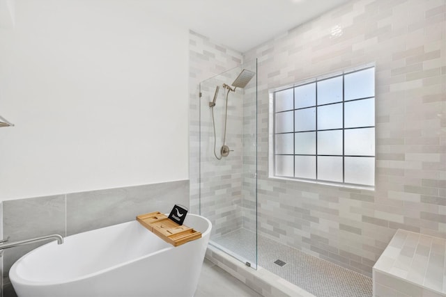 bathroom featuring shower with separate bathtub