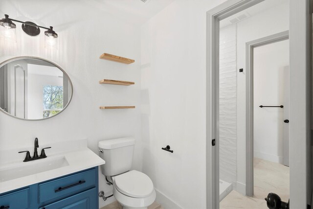 bathroom featuring vanity, a shower, and toilet